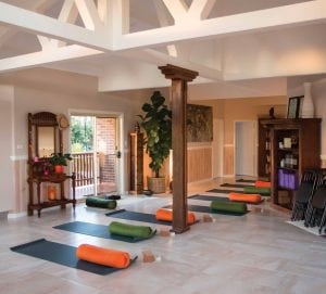 Photo of a yoga studio with mats and bolsters set up.