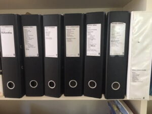 Image of 7 lever arch files on a shelf