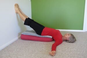 Eve demonstrating a bolster supported yoga pose for good health