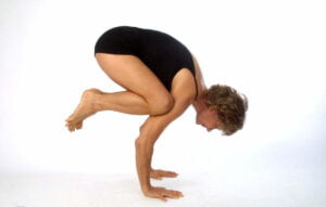 Image of a yoga teacher doing an advanced arm balancing pose